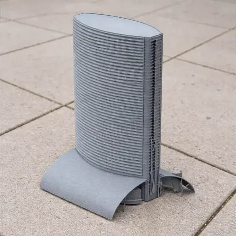 3D-printed model of a modern, curved skyscraper with a unique base design on a tiled surface.