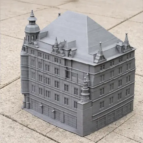 3D-printed model of a detailed multi-story historic building with a pitched roof and towers.
