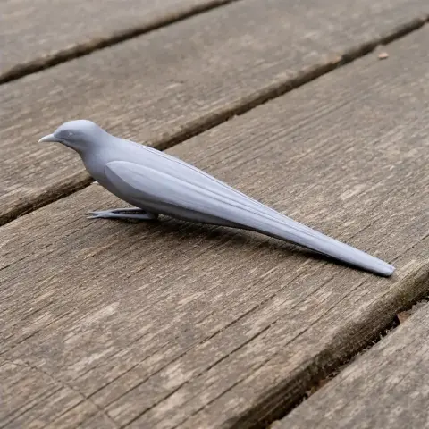 Gray 3D-printed model of a cicadabird, positioned on wooden planks, showcasing its streamlined form.