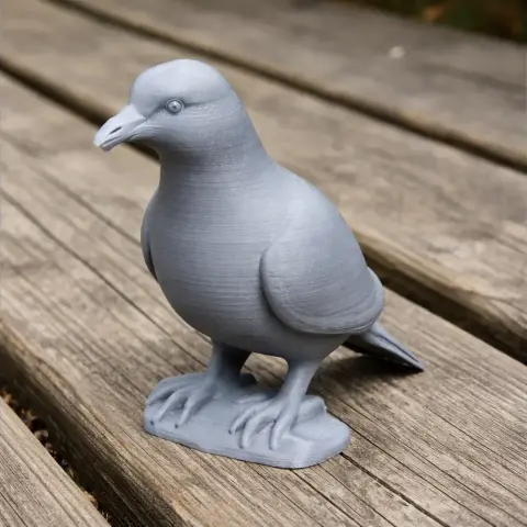 Gray 3D-printed model of a pigeon on a wooden surface.
