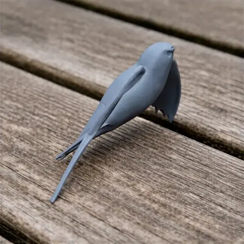 A 3D printed model of a bird with streamlined wings, resting on a wooden surface.