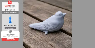Gray 3D-printed model of a bird with detailed feathers, resting on a wooden surface.