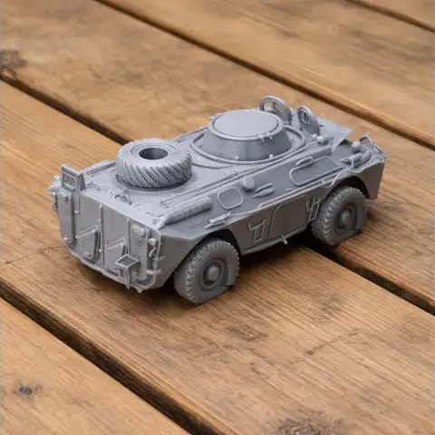 Gray 3D-printed model of an armored military tank with detailed surface features, on a wooden surface.