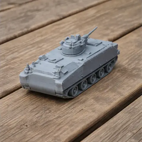 Gray 3D-printed model of a tank with turret and tracks on a wooden surface.