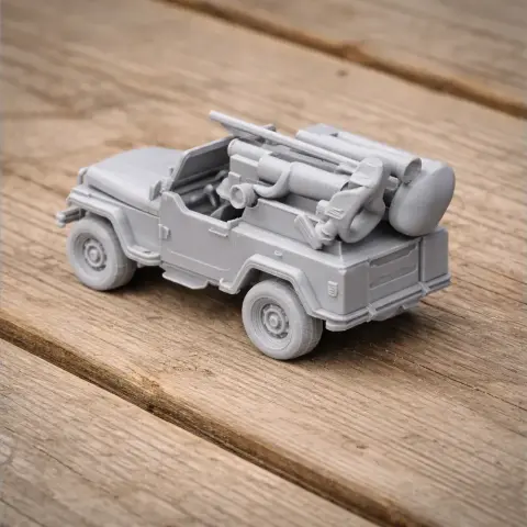 3D-printed military jeep with mounted weaponry on a wooden surface.