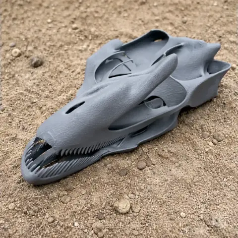 3D-printed Antrodemus skull replica on sandy ground, showing detailed structure and textured surface.