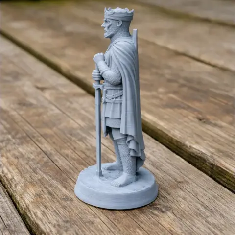 A 3D-printed knight figure with a crown, cape, and armor, holding a sword upright on a base.
