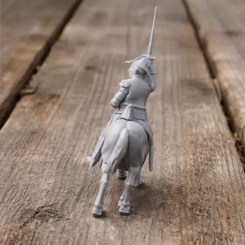 Napoleonic soldier on horseback with raised sword, facing forward on a wooden surface.