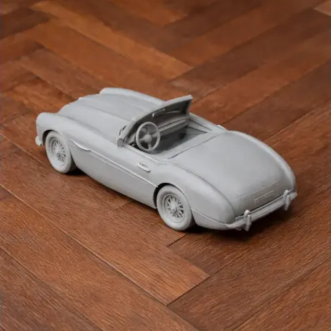 3D printed scale model of a classic Austin-Healey 100-6 convertible on a wooden surface.