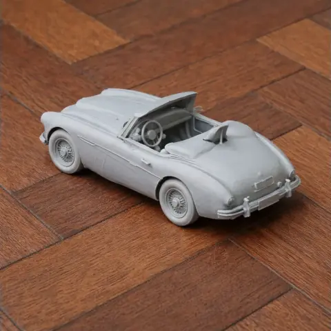3D printed model of an Austin-Healey 3000 convertible car on a wooden surface.