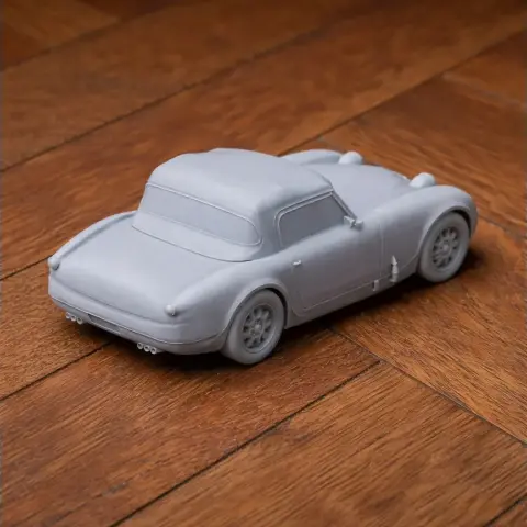 A detailed 3D-printed model of an Austin-Healey Sprite car on a wooden surface.