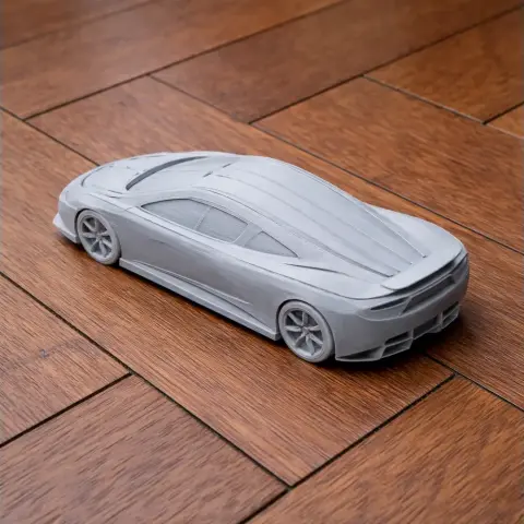 3D printed scale model of a sleek sports car on a wooden surface.