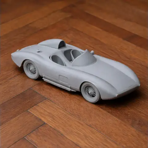 3D printed model of a vintage Bandini convertible car on a wooden surface.