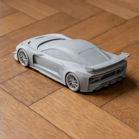 A detailed 3D-printed scale model of a sleek car on a wooden surface.