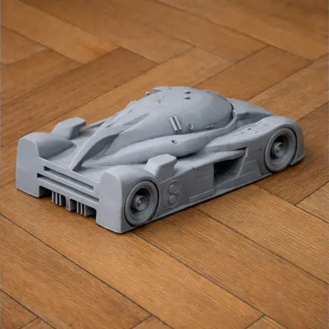 3D-printed Bentley Speed 8 model, gray, on wooden floor.