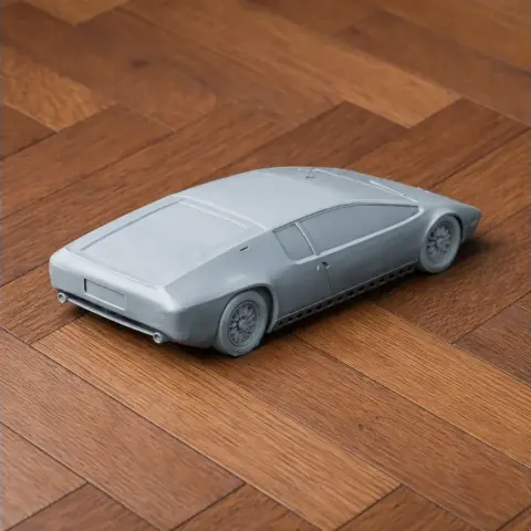 3D printed model of a sleek, futuristic car on a wooden surface, showcasing aerodynamic design.