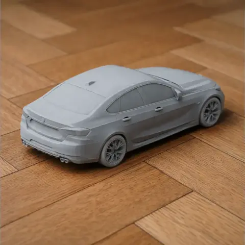 3D printed model of a BMW 2 Series car on a wooden surface.