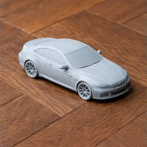 3D printed model of a BMW E63 car on a wooden surface.