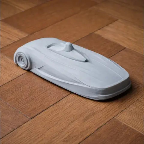 Streamlined gray 3D-printed model of a BMW H2R vehicle on a wooden surface.