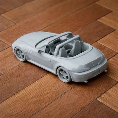 A 3D printed BMW M Roadster scale model on a wooden surface.