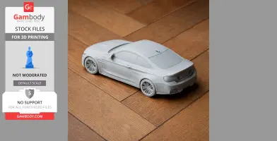 3D-printed model of a BMW M4 DTM car on a wooden surface.