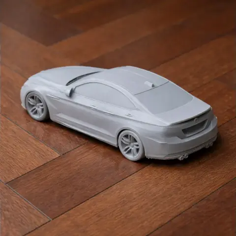BMW M6 3D printed model in gray on a wooden surface, showcasing the car's sleek design.
