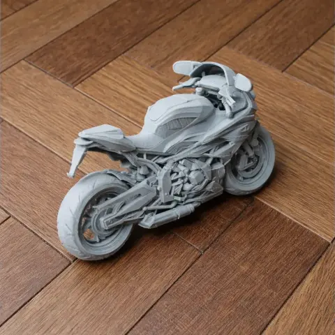 Gray 3D-printed model of a BMW S1000RR motorcycle on a wooden surface.