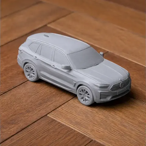 A detailed 3D printed model of a BMW X3 scale vehicle on a wooden surface.