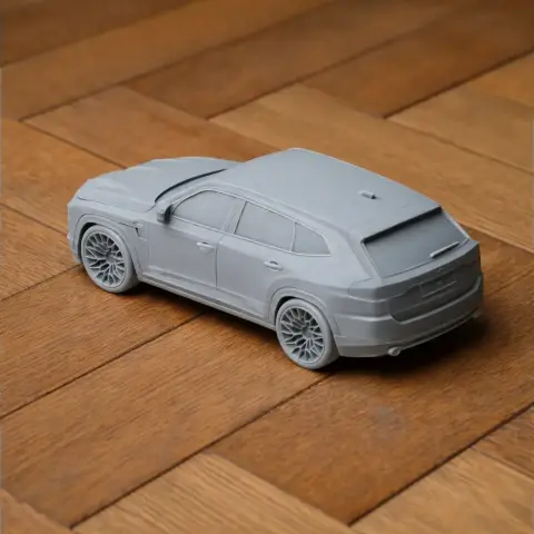 3D-printed model of a BMW XM car on a wooden surface.