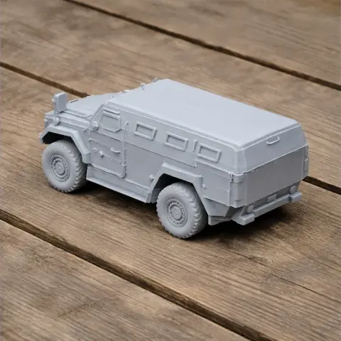 Gray 3D-printed armored vehicle model on a wooden surface.