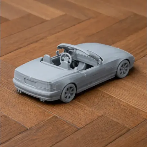 3D printed BMW Z1 scale model on wooden floor, showcasing convertible design and detailed wheels.