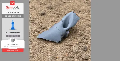 A small, gray 3D-printed Avaceratops skull rests on a sandy surface.