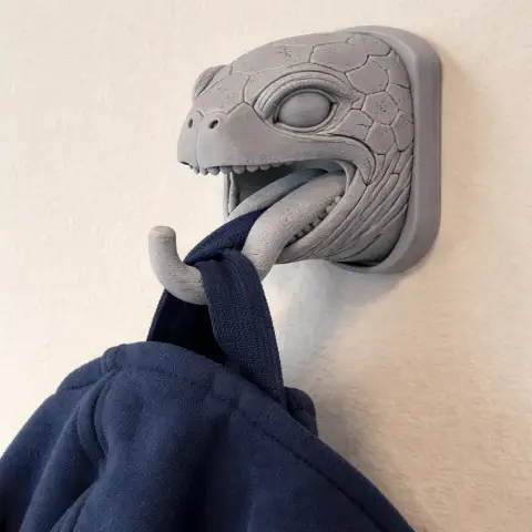 Turtle-themed wall hook with a turtle head design holds a coat through its mouth.