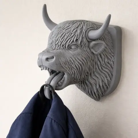3D-printed yak head wall hook holding a coat with its mouth.