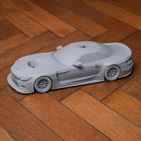 3D-printed gray model of a BMW Z4 GTE car on wooden flooring.