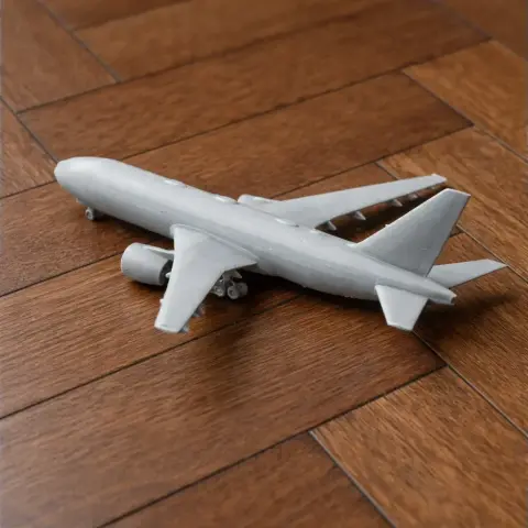 3D-printed model of a Boeing 777 airplane on a wooden surface.