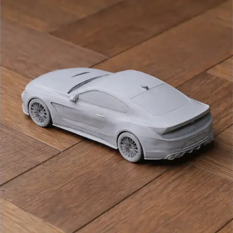 3D printed model of a sleek sports car on a wooden surface.