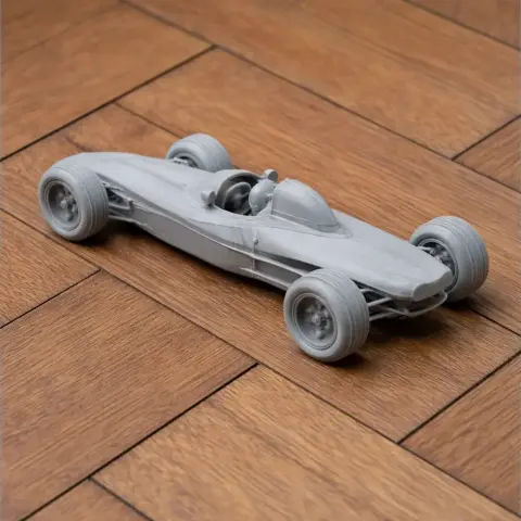 A detailed 3D-printed scale model of a Brabham racing car on a wooden surface.