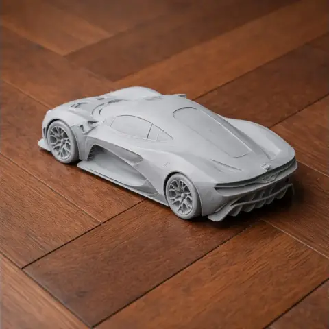 3D-printed model of a sleek Brabham BT62 race car on a wooden surface.