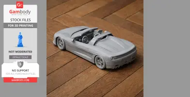 Gray 3D-printed convertible sports car on wooden surface, side and rear view.