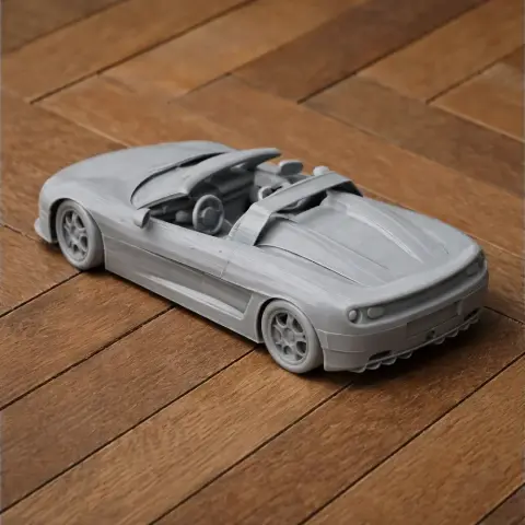 A detailed 3D-printed model of a convertible sports car, showcased on a wooden surface.