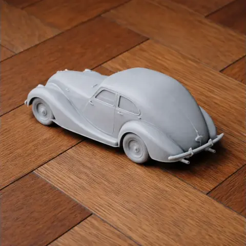 3D printed model of a vintage Bristol car on a wooden floor.