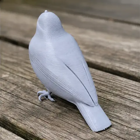 3D printed model of a bird perched on a wooden surface, viewed from the back.