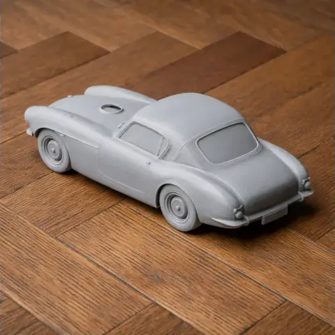 3D-printed scale model of a vintage sports coupe on a wooden floor.