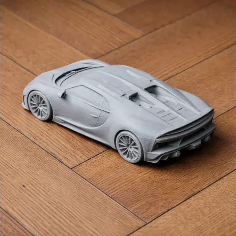 3D printed model of a sleek, aerodynamic sports car on a wooden floor.