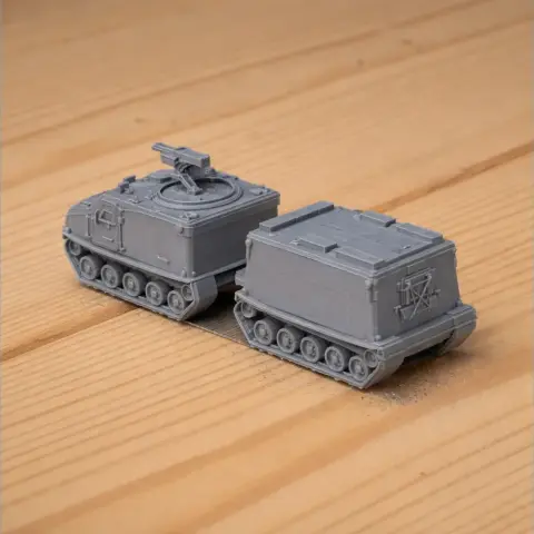 Two gray, 3D-printed models of Bandvagn 206 vehicles with tracked wheels on a wooden surface.