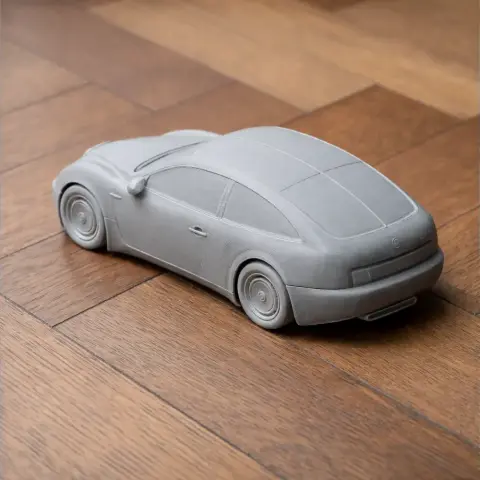 3D-printed model of a Bugatti EB 112 car on a wooden surface.