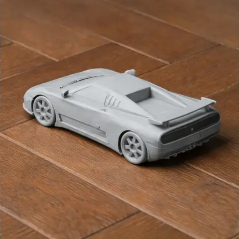 3D-printed Bugatti EB110 model on wooden surface, rear view.
