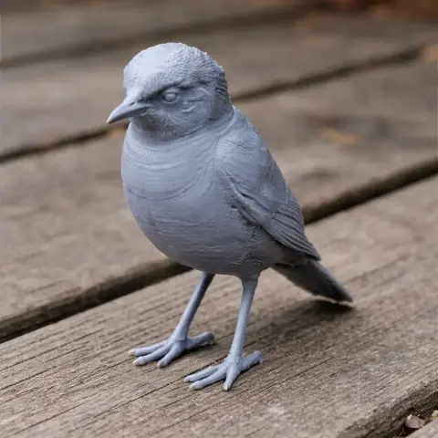 Gray 3D-printed bird figurine with detailed feathers, standing on wooden surface.