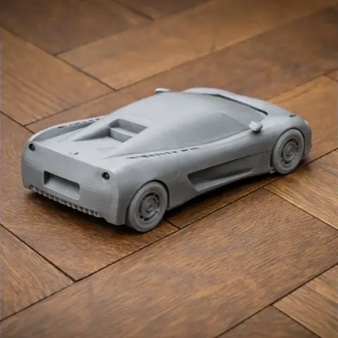 3D-printed Bugatti ID90 model on a wooden surface, showcasing sleek rear design and smooth contours.